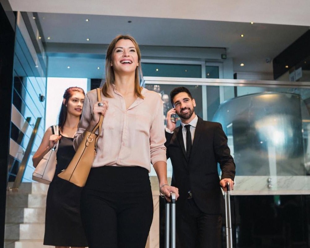 Hotel guests with luggage arriving in a modern lobby for self check-in