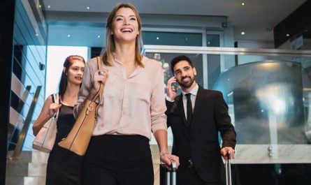 Hotel guests with luggage arriving in a modern lobby for self check-in