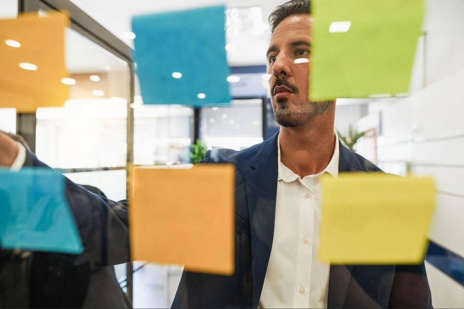 Analyst mapping commercial due diligence checkpoints on a glass board in a Dubai office